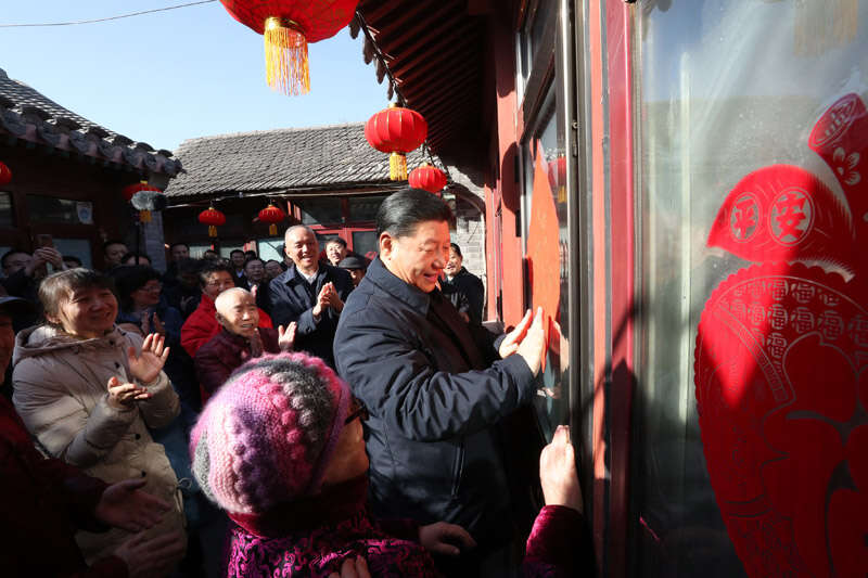 2019年2月1日上午，習(xí)近平在北京前門(mén)東區(qū)草廠四條胡同32號(hào)院，高興地拿起一幅“?！弊?，親自貼到門(mén)上，給這里的老街坊們拜年。新華社記者 鞠鵬 攝