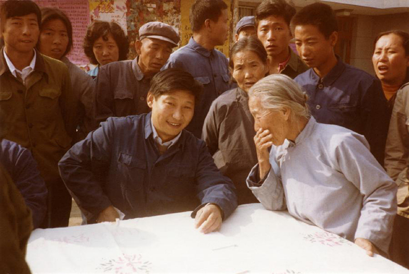 1983年，時(shí)任河北正定縣委書記的習(xí)近平（前排居中），臨時(shí)在大街上擺桌子聽取老百姓意見。