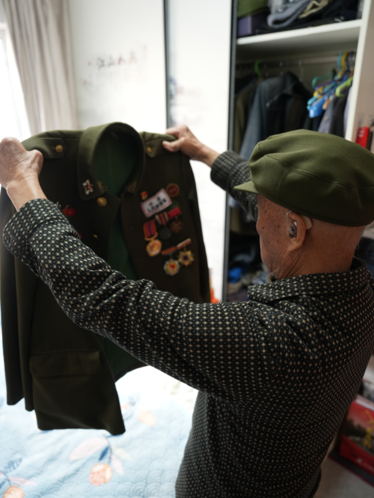 李維波老人整理軍裝。人民網(wǎng)記者 周頌雪攝